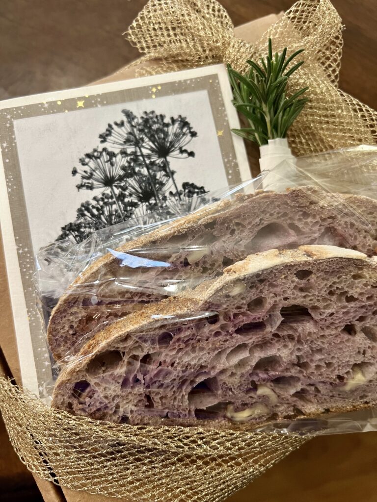 Gift Box Exterior with gold ribbon, artisan card, blue corn walnut sourdough slices and a rosemary sprig garnish